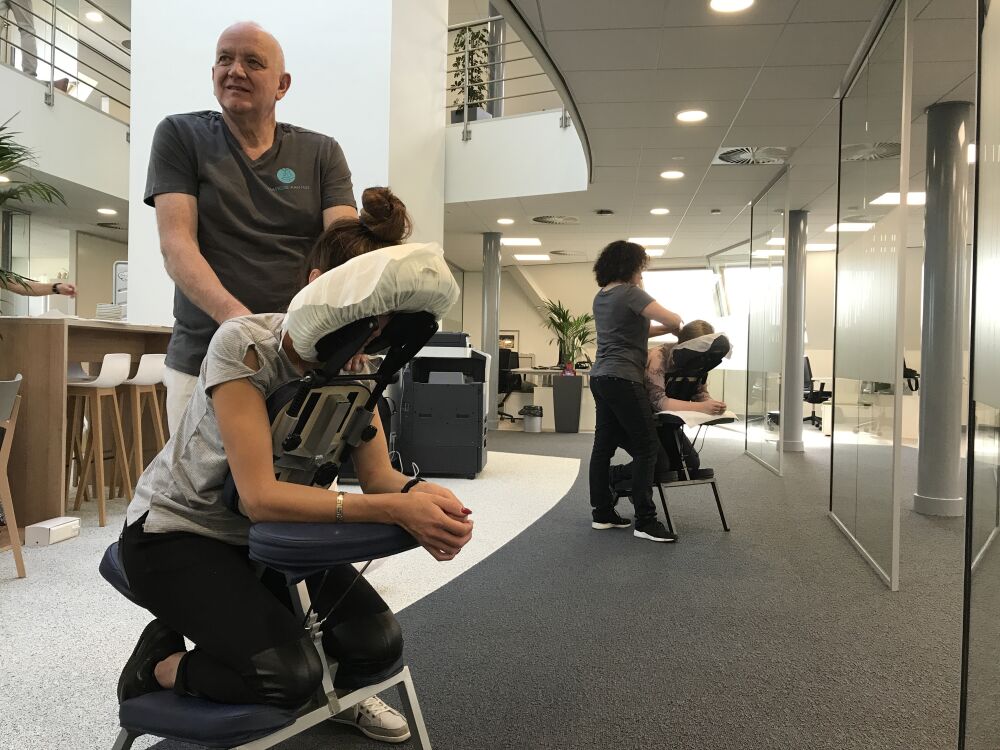 Mensen die elkaar massages geven in een massagestoel