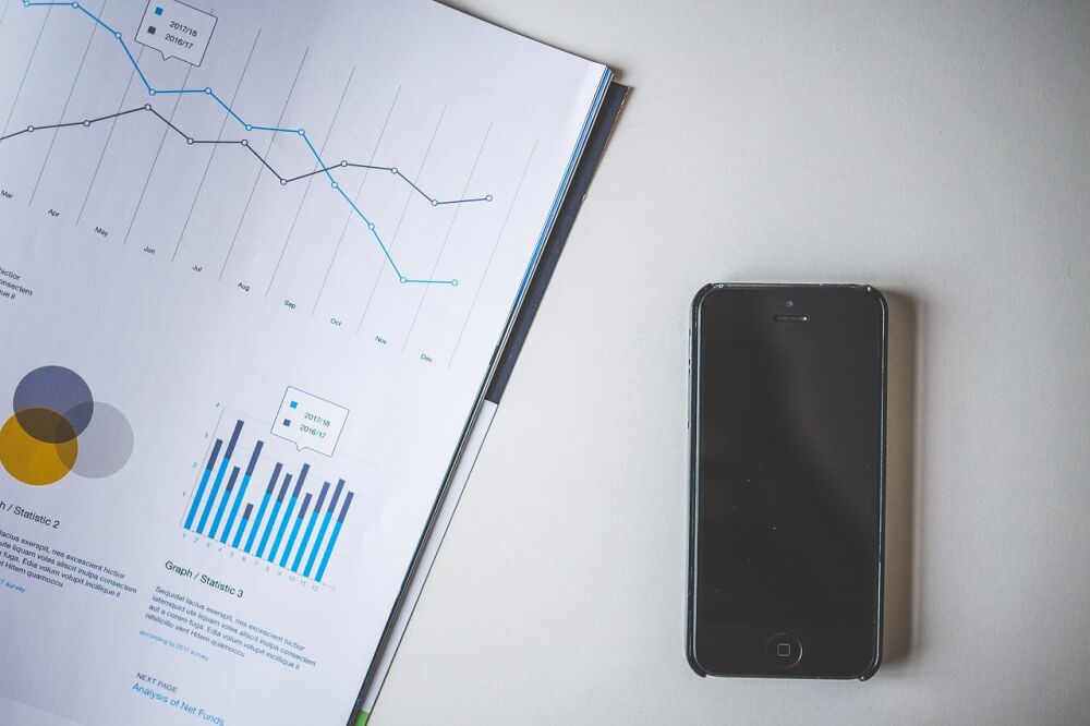 Een datasheet met smartphone die een overzicht tonen van de data die een CRM in de zorg kan bieden.