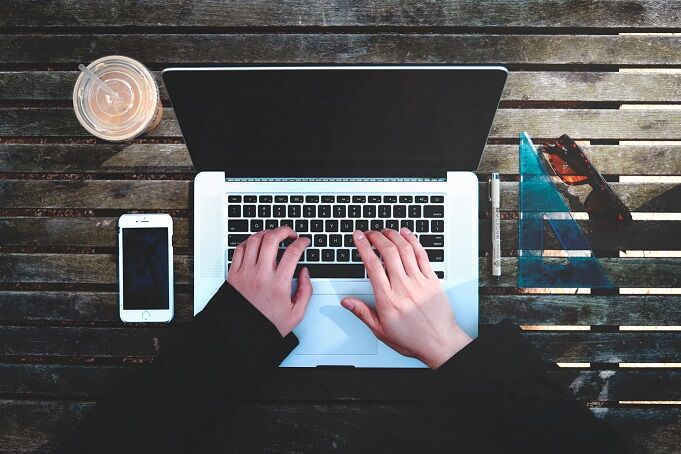 Twee handen typend op een laptop aan het werk met de Exact Globe eindejaarsverwerking