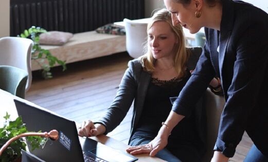 Twee vrouwelijke collega's die een afweging maken tussen het Exact Globe en Exact Online abonnement.